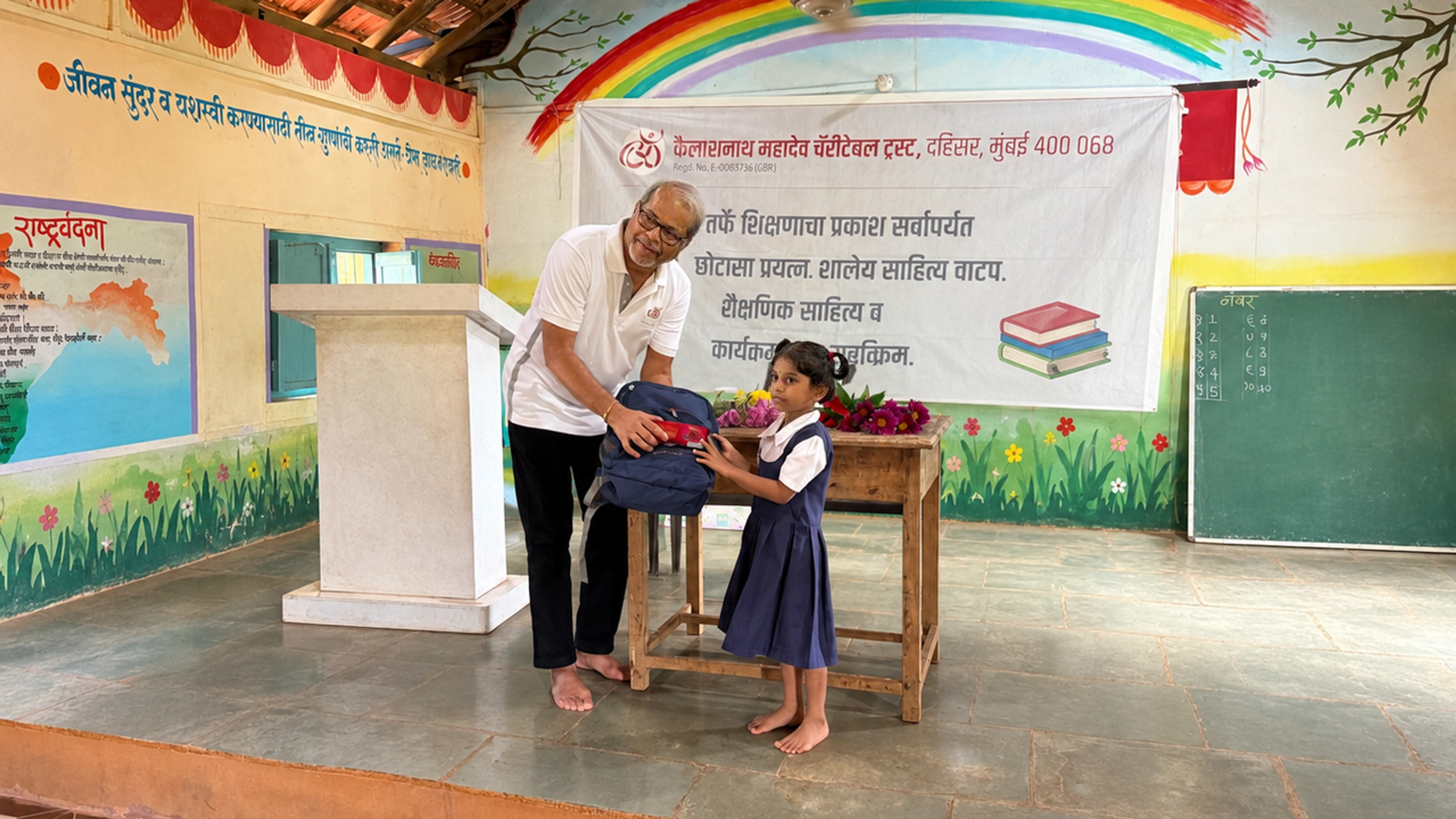 A donor and a schoolgirl holding a new school bag together at a Trust school visit